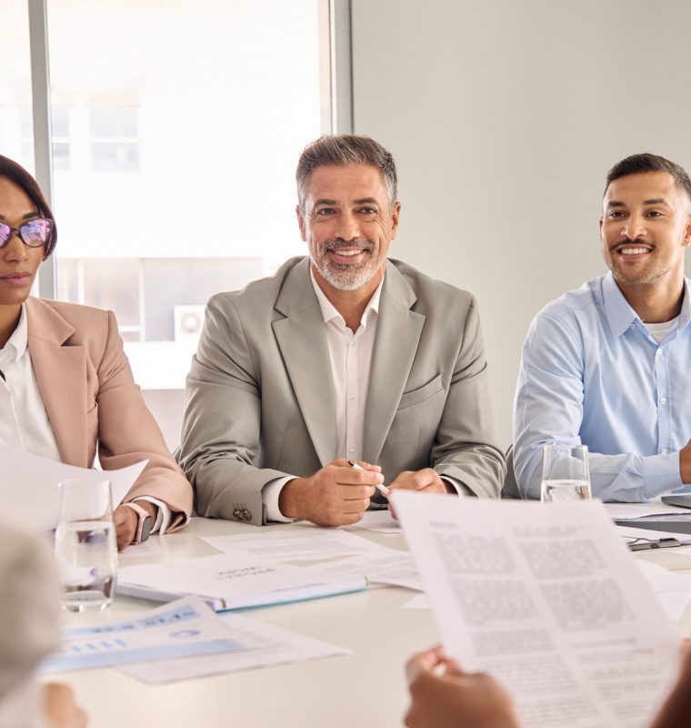 Happy diverse executive board work group talking at office meeting. Busy diverse professional workers team consulting managing project, having discussion at corporate boardroom table.