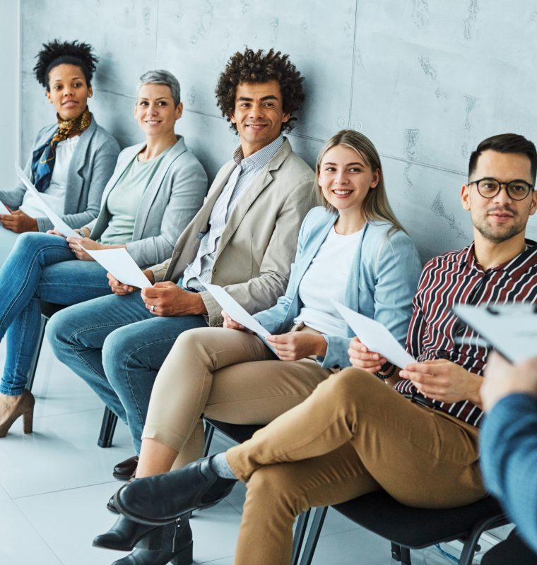 Group of young businss people sitting in chairs and waiting for an interview